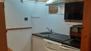 A compact kitchen with a sink, a microwave, and a refrigerator.