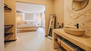 Une salle de bain moderne avec un grand lavabo ovale, un miroir et une douche à l’italienne.