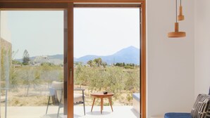 Una sala de estar moderna con un amplio ventanal corredero que da a un patio exterior.
