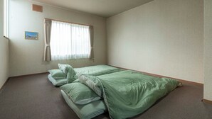 A small, sparsely furnished room with a single bed, a window with curtains, and a small picture on the wall. - One-room private inn Koropokkuru (中富良野町字中富良野東１線)