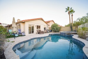 Un jardin avec une piscine, des meubles de patio et un jacuzzi.