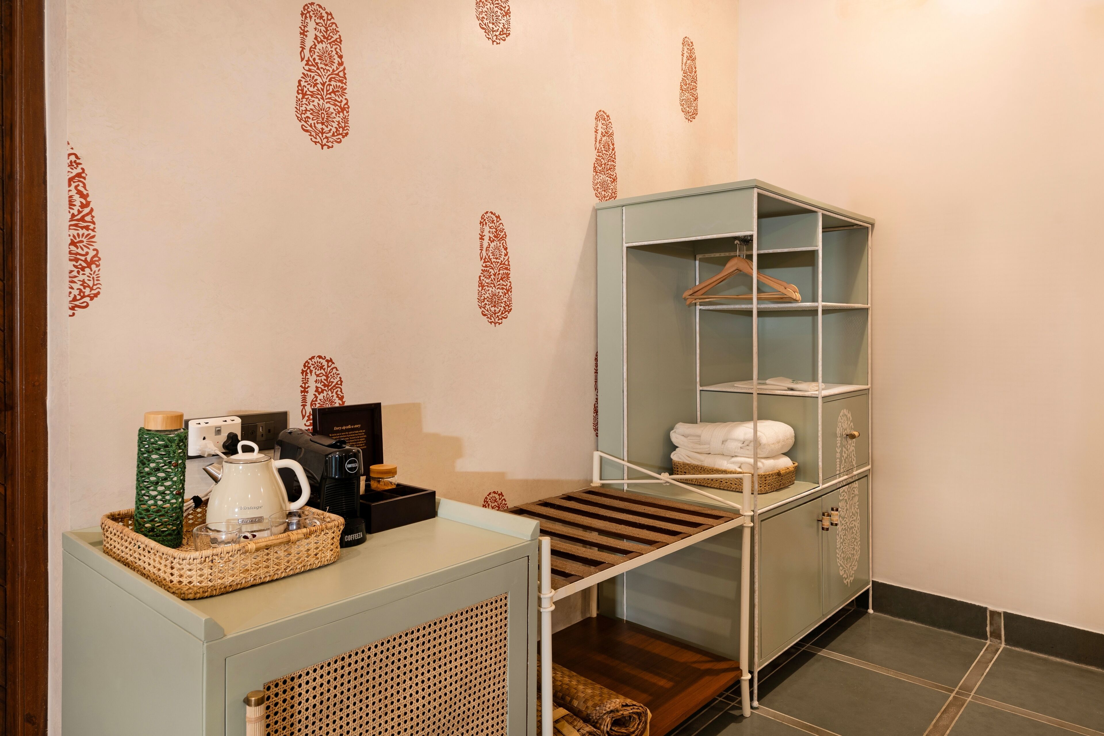 Une salle de bain avec une étagère en bois, un porte-serviettes et un panier contenant des articles de toilette.