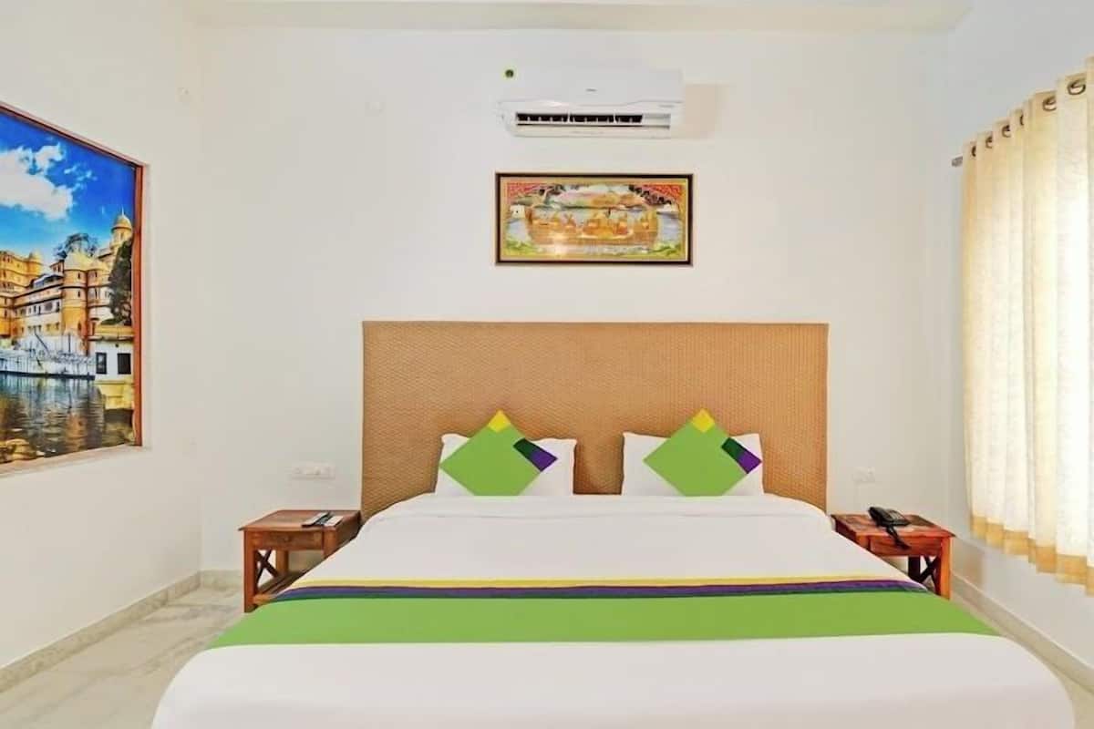 Une chambre d’hôtel avec un lit, un tableau, un climatiseur et un rideau.