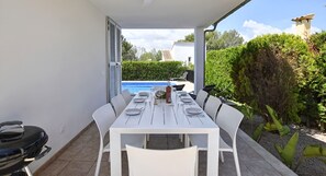 A white table set for dining outdoors with a pool in the background. - Holiday Home 'La Calma - Solar 193' with Private Pool, Wi-Fi and Air Conditioning (Puerto de Alcudia)