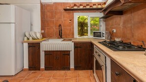 A kitchen with a refrigerator, stove, microwave, and wooden cabinets.