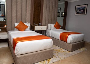 A hotel room with two beds, a nightstand, a mirror, and a framed picture on the wall. - Villa Angelia Hotel & Chinese Restaurant (Lagos)