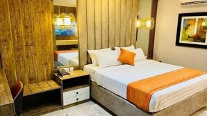 A bedroom with a large bed, bedside tables, a desk, and a chair. - Villa Angelia Hotel & Chinese Restaurant (Lagos)