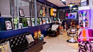 A modern bar with a black leather sofa, a TV, and a bar counter with bottles. - Villa Angelia Hotel & Chinese Restaurant (Lagos)