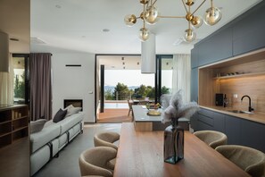 A modern living room with a sofa, dining table, and kitchen area. - Villa Calvi Zadarvillas (Zadar)