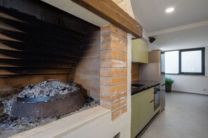 Una cocina con chimenea de ladrillo, un lavamanos y armarios.