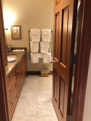 A bathroom with a sink, mirror, and towel rack.
