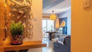 A modern living room with a sofa, a dining table with chairs, and a potted plant. - Bayview 2-BR Apartment in Larnaca (Larnaca)