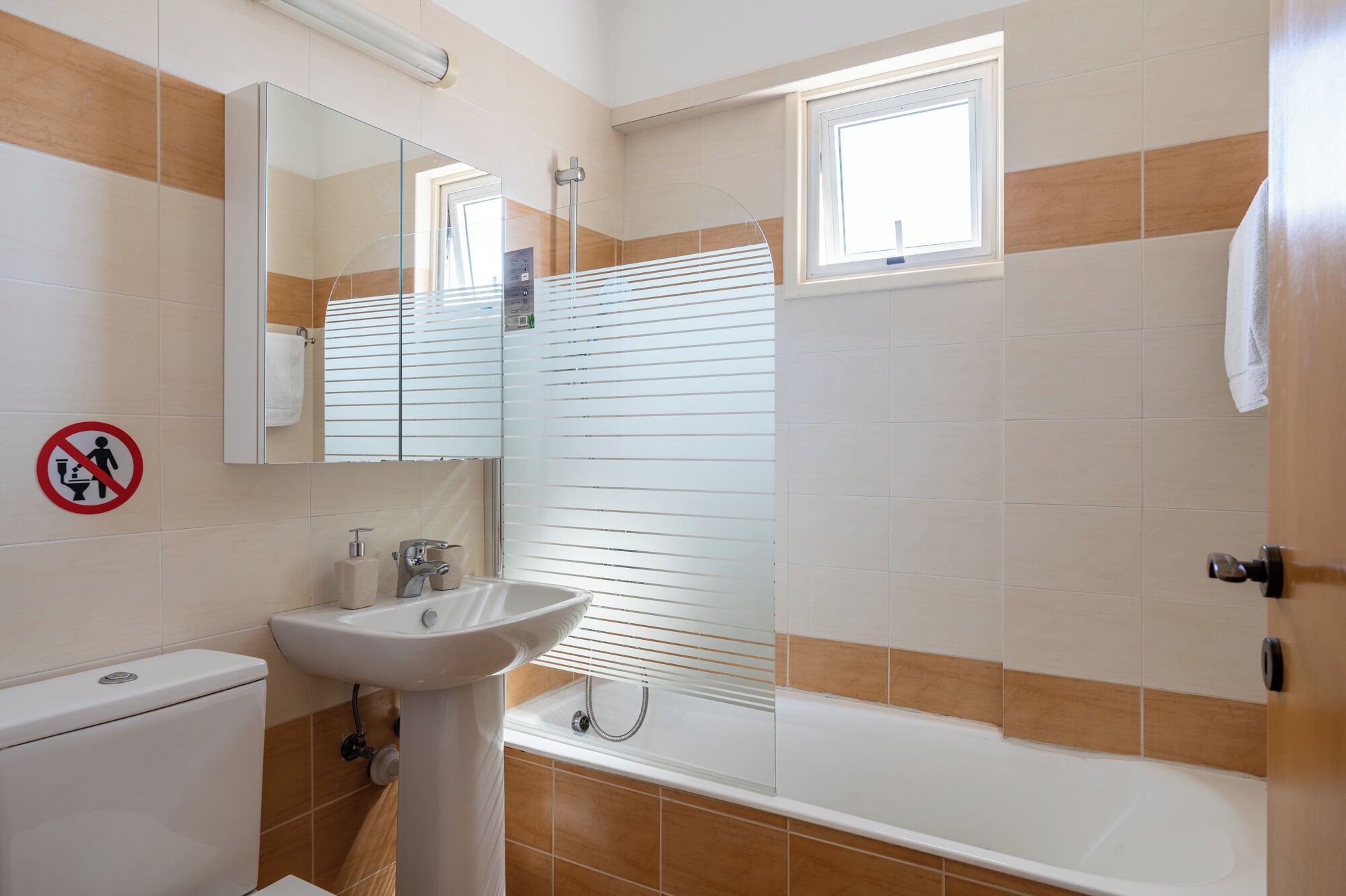 A bathroom with a toilet, sink, and bathtub.