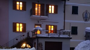A multi-story building with snow-covered roofs and balconies. - Apartment 'Odorizzi Dolomiti Di Brenta' with Mountain View, Shared Garden and Balcony (Tassullo)