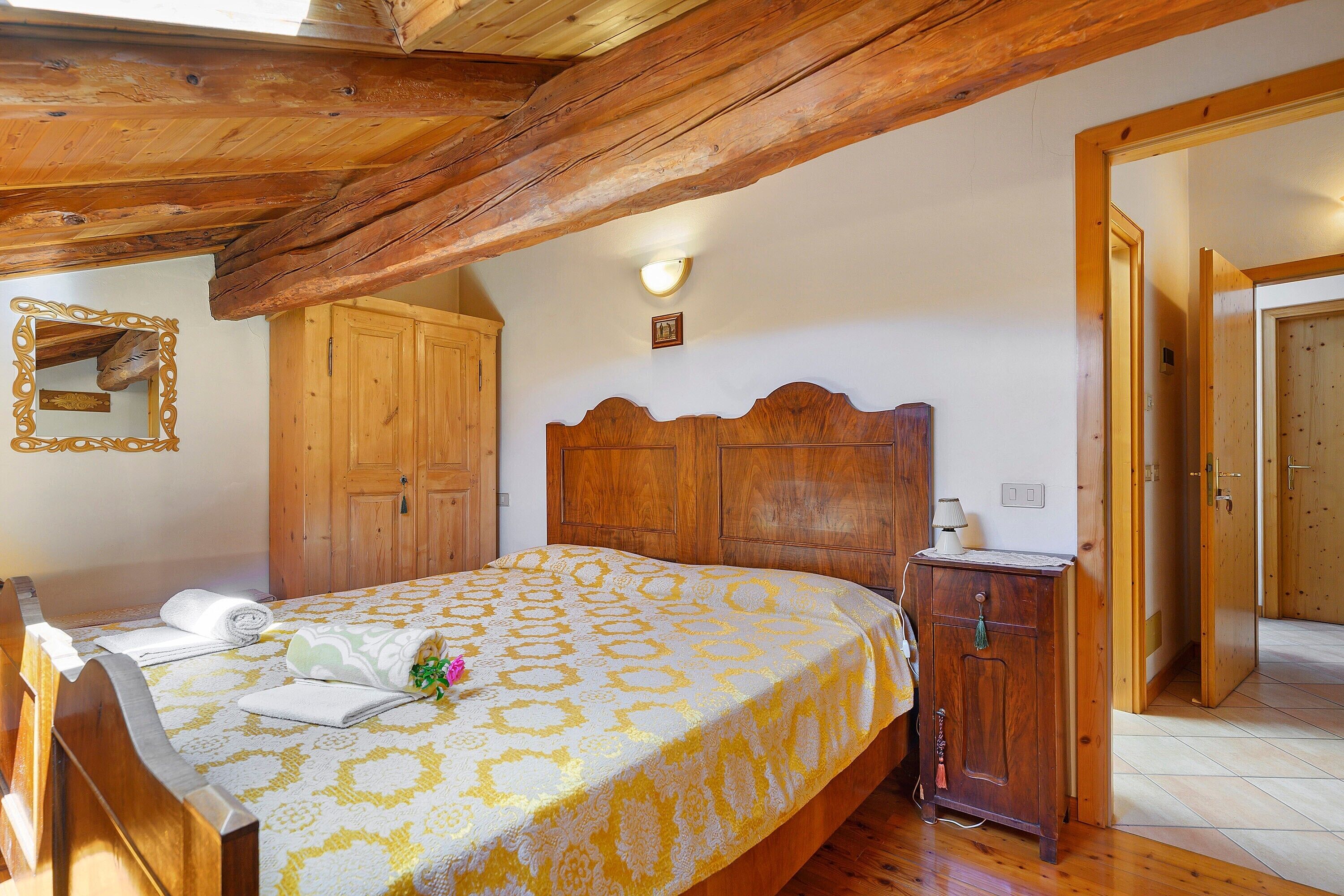 Un dormitorio con una cama, un armario y un aparador de madera.