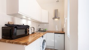 A compact kitchen with a microwave, toaster, sink, and dishwasher.