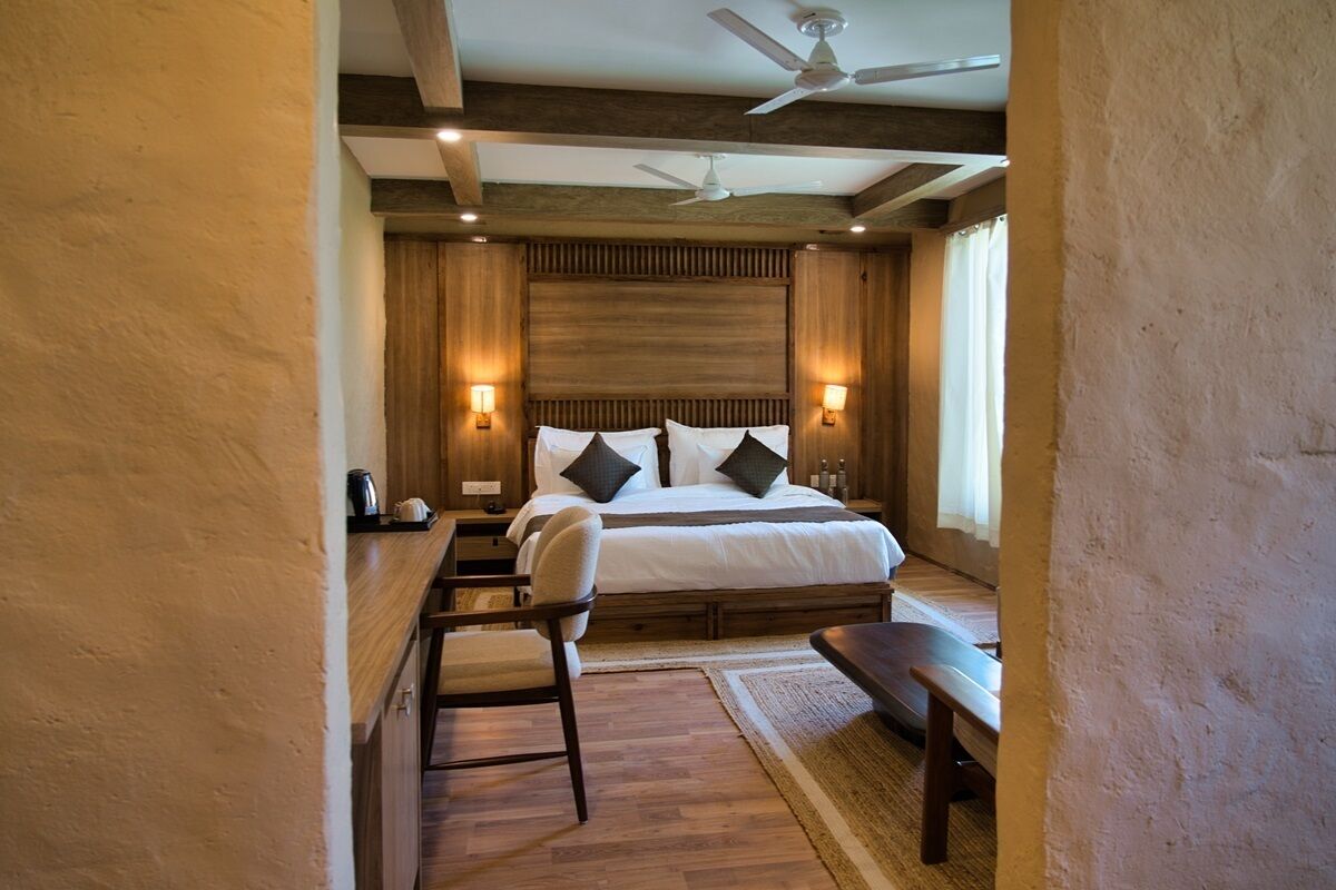 A bedroom with a large bed, bedside tables, a desk, and a chair.