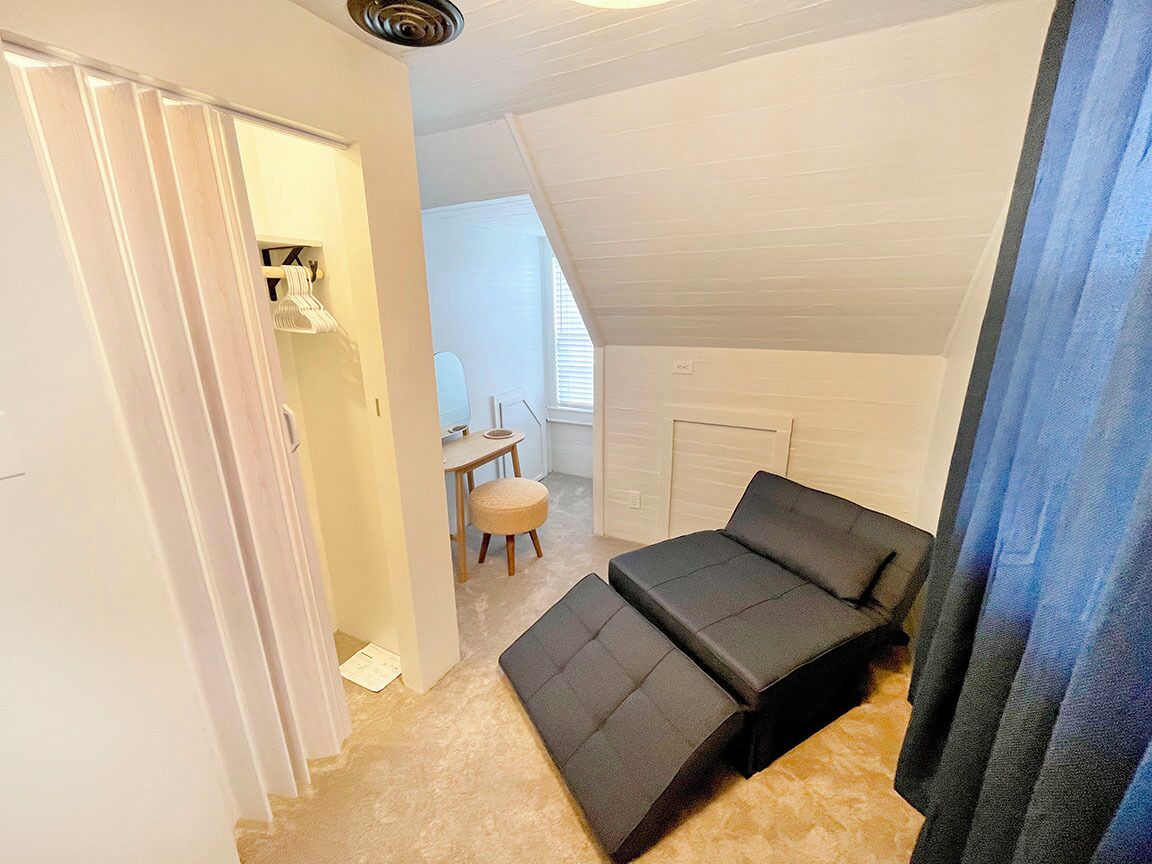 Ein kleiner, kompakter Raum mit Schlafsofa, Tisch und Stuhl.
