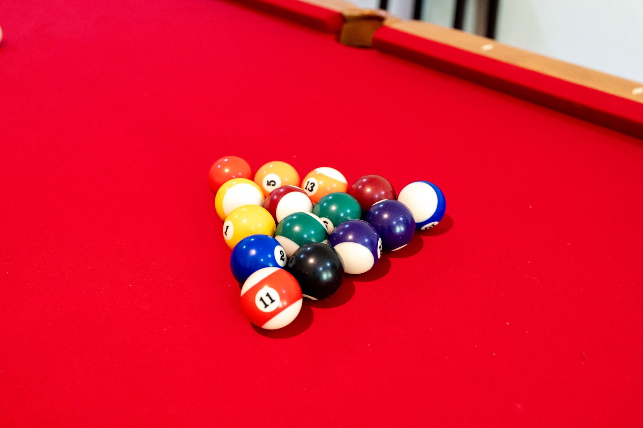 Een pooltafel met een rode viltkleed en een los hoek.