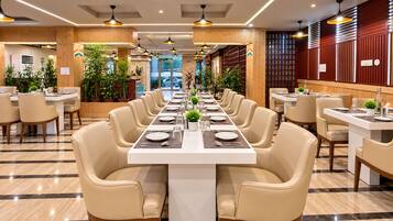 Un restaurante con una larga mesa de comedor lista para una comida, rodeada de sillas.