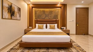 Ein Hotelzimmer mit einem großen Bett, einem Kopfteil mit Blattmustern, einem Nachttisch mit Telefon und einer Tür mit Schloss.