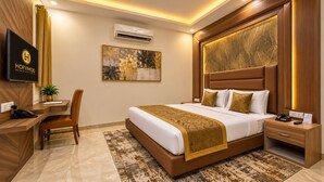 A hotel room with a bed, bedside table, desk, chair, and a television. - Hotel Lohmod (New Delhi)