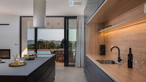 Una cocina moderna con una isla grande, horno integrado y vistas al exterior.