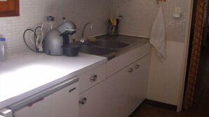 A compact kitchen with white cabinets, a sink, and a kettle. - Collioure large apartment terrace swimming pool garage air-conditioning exceptional view. (Collioure)