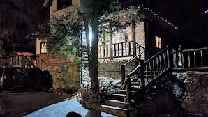 A stone building with a wooden staircase and a car parked outside.