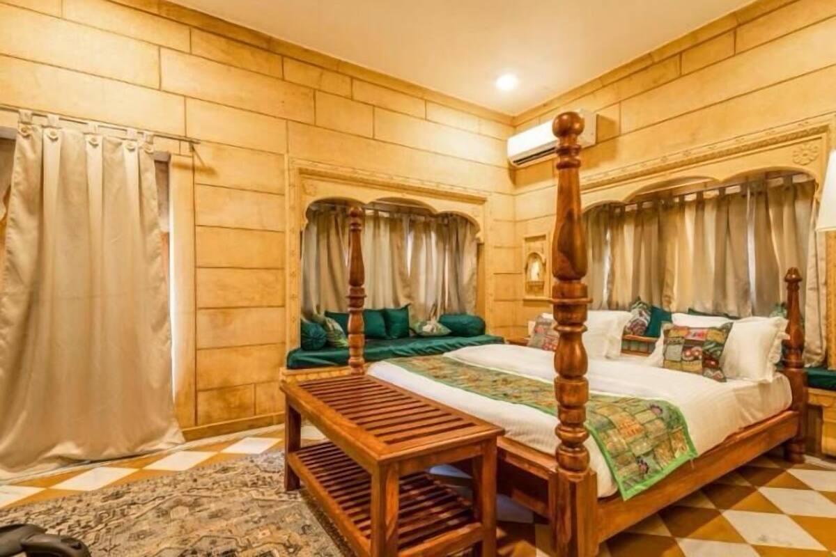 A four-poster bed with a wooden headboard, a bedside table, and a patterned rug on a checkered floor.