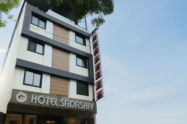 A multi-story building with a sign reading "HOTEL SADASHIV".