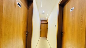 Ein Flur mit Holztüren, die mit Nummern versehen sind, der zu einem Zimmer führt.