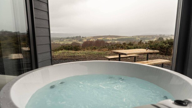 A hot tub with a view of a rural landscape. - Migdale Heights - Luxury Cabins in The Highlands (Ardgay)