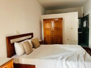 Eenvoudige tweepersoonskamer | Badkamer | Een douche, handdoeken, zeep, shampoo