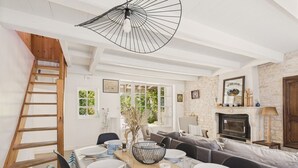 A dining area with a wooden ladder, a fireplace, and a stone wall. - 400 m from the beach, garden, house for 8 (Saint-Clément-des-Baleines)