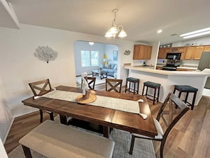 A dining area with a wooden table, chairs, and a central decorative piece. - DeStoto Canal Oasis w/ Boat Lift. Walk to Beach! (St. Augustine)