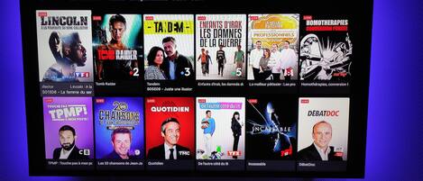 A TV channel interface with various live TV show thumbnails.