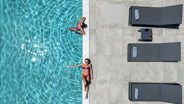 Ein Swimmingpool mit zwei Liegestühlen und einem Handtuchhalter.