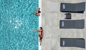 Alberca al aire libre, sombrillas en la alberca y camastros 