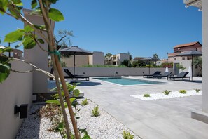 Piscine extérieure, parasols de plage, chaises longues