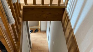Un escalier en bois, doté d’une rampe, menant à l’étage supérieur.