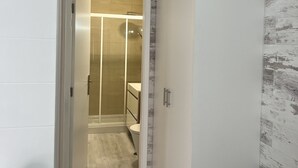 Un baño moderno con ducha, inodoro y tocador.