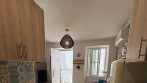 Une cuisine moderne avec des meubles en bois, un pare-feu en carrelage, un four encastré et un coin repas comprenant un canapé et une fenêtre.