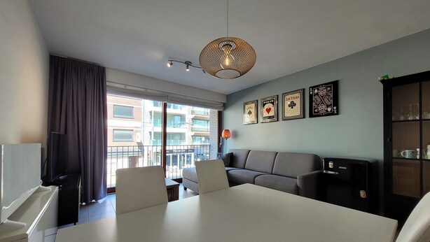 Una sala moderna con un sofá, una mesa de comedor y una cafetera.