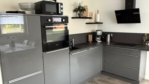 A modern kitchen with a built-in oven, microwave, and a gas stove. - OsWALD Holiday Apartment (Ettenheim)