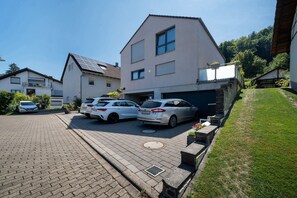 Un quartier résidentiel avec des maisons modernes, une allée pavée et des voitures garées.