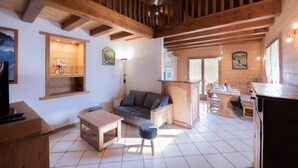 Ein Holzinterieur mit einer Couch, einem Esstisch und einer Küchenzeile.