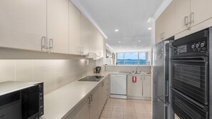 A modern kitchen with a dishwasher, stove, and oven.