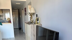 Ett modernt vardagsrum med en platt-TV, ett soffbord i trä och ett golv av marmor.