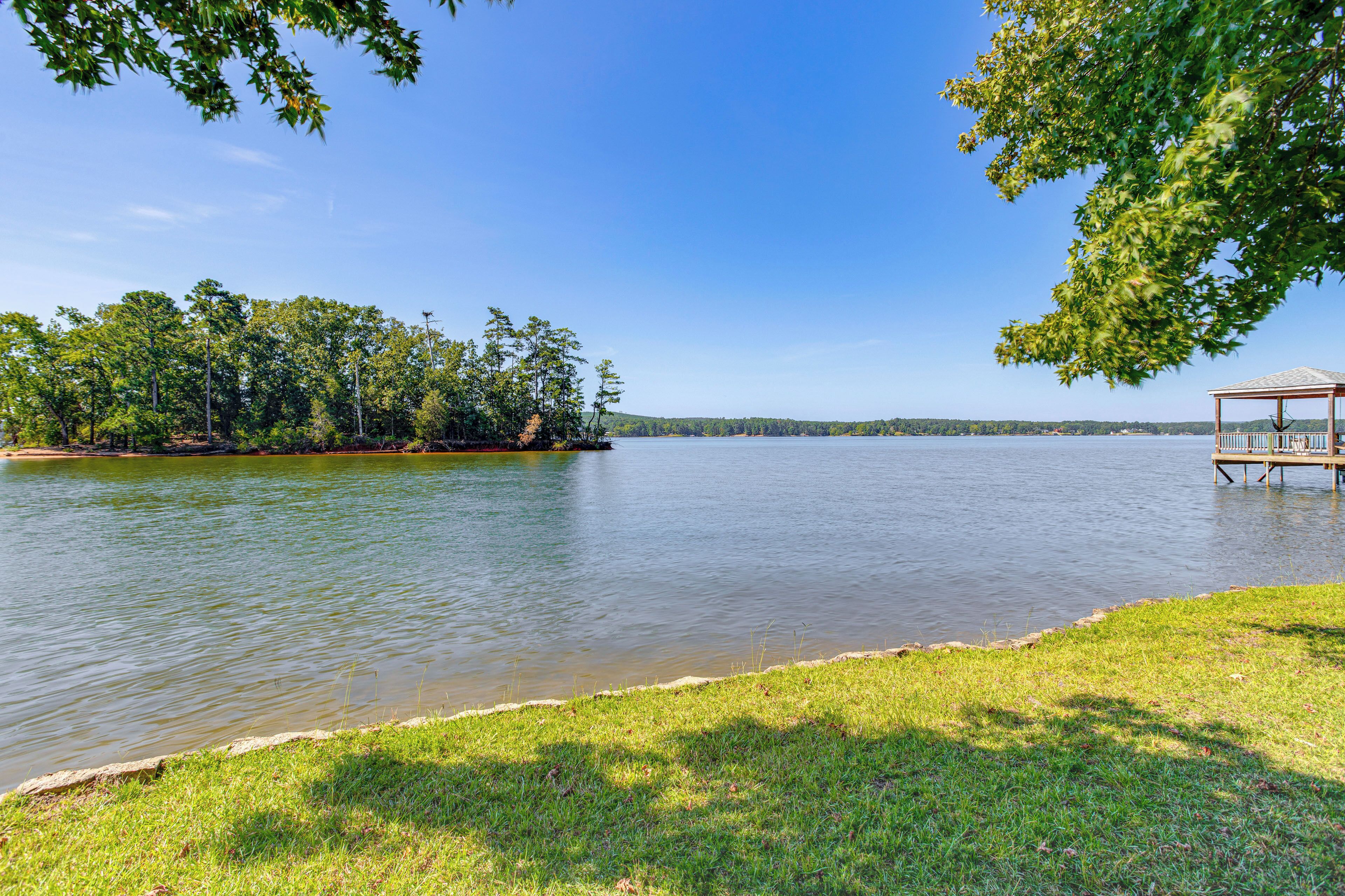 A lakeside view with a gazebo and grassy area.